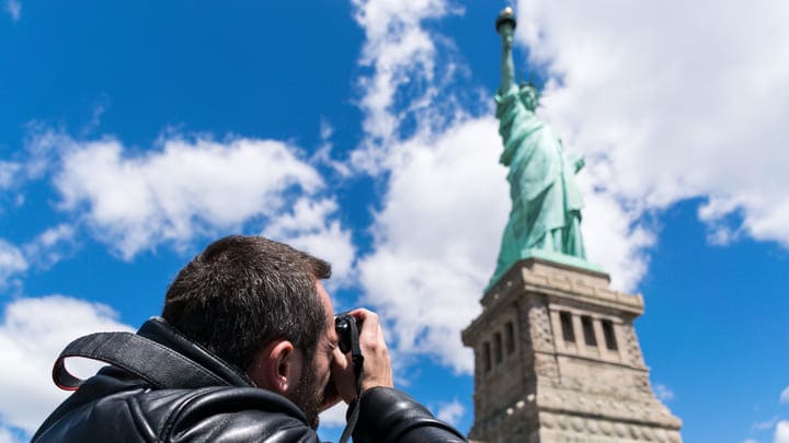 Man photographing the Statue of Liberty