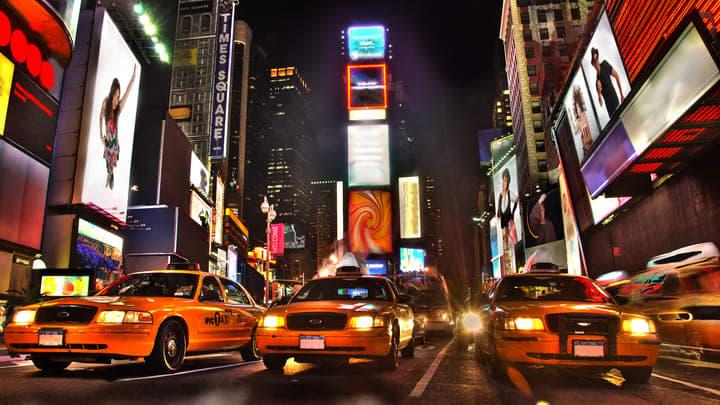Classic yellow cabs and bright lights on Times Square, New York