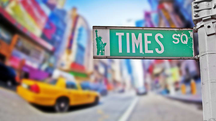 Times Square street sign and yellow NYC cab